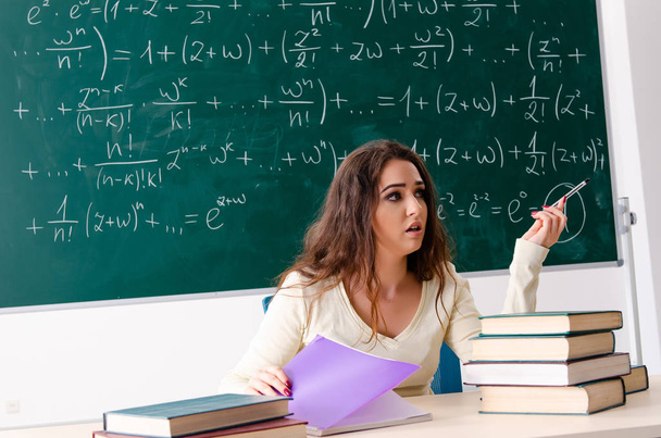 Молодая учительница математики перед доской   - Фото, изображение