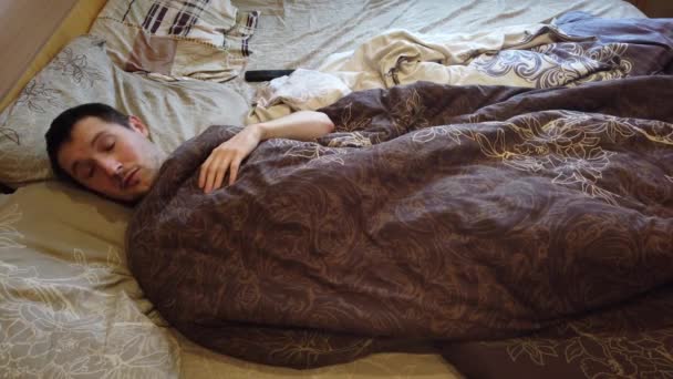 Homme dormant et se réveillant seul dans le lit, près du visage. Coup de tête d'adulte caucasien homme dans la trentaine avec la tête sur l'oreiller le matin
. - Séquence, vidéo