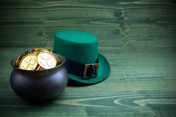 Happy St Patricks Day leprechaun hat with gold coins on vintage style green wood - Foto, Imagem