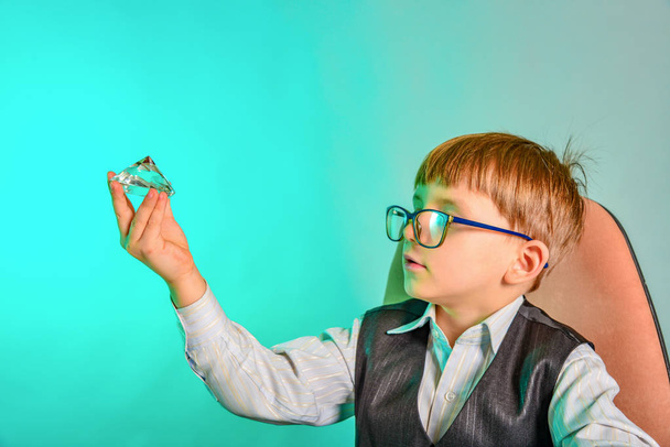 El niño estudia la gema a través de gafas, el concepto de niños, negocios, joyas
 - Foto, Imagen