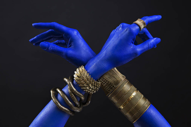 Blue woman's hands with indian gold jewelry. Oriental Bracelets  - Photo, Image