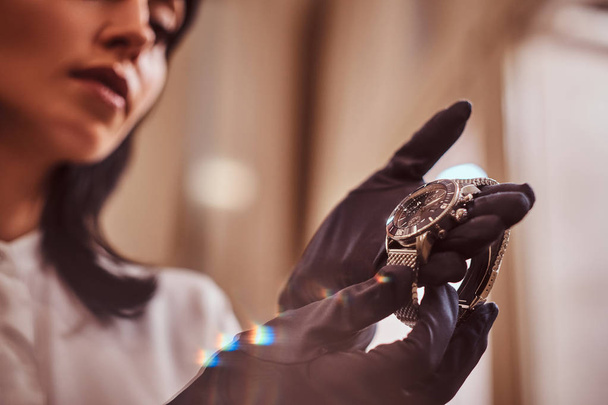 Seller shows an exclusive mens wristwatch from the new collection in the luxury jewelry store - Foto, afbeelding