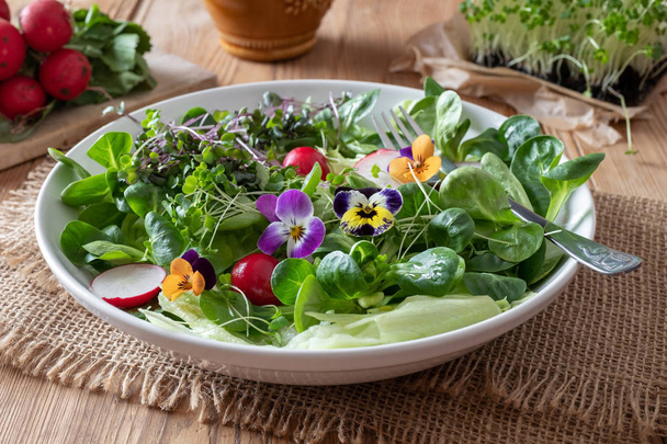 Salad with edible pansies and fresh broccoli and kale microgreen - Photo, Image
