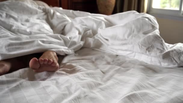 毛布の下の女性の脚のペア。4 k - 映像、動画