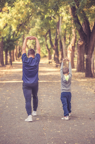 Baba ve küçük oğlu birlikte parkta egzersiz - Fotoğraf, Görsel