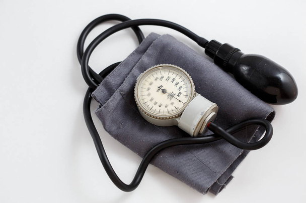 Concept voor geneeskunde. Vintage tonometer en stethoscoop op witte geïsoleerde achtergrond. Van bovenaf bekijken - Foto, afbeelding