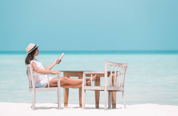 Young woman reading book during tropical maldivian beach - Φωτογραφία, εικόνα