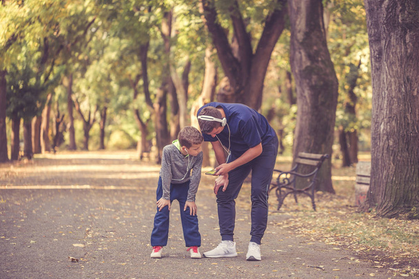 Little boy and his father taking a break after training - 写真・画像
