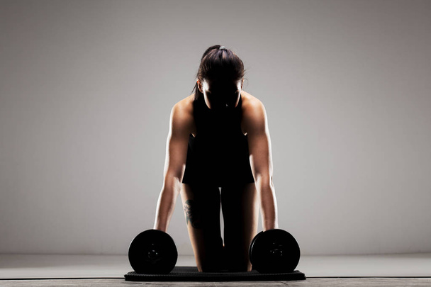 fitness girl doing push ups with weights. half silhouette - Фото, зображення
