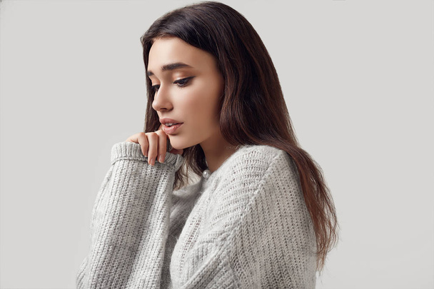 Bella donna bruna in maglione in posa in studio
 - Foto, immagini