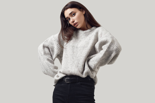 Beautiful brunette woman in sweater posing in studio - Foto, Bild