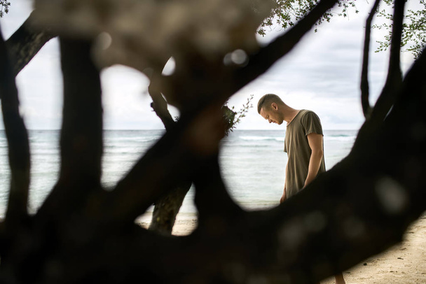 Komea kaveri seisoo trooppisella hiekkarannalla
 - Valokuva, kuva