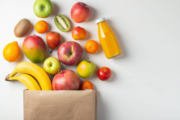 Бумажный пакет с фруктами для здоровья на столе
. - Фото, изображение
