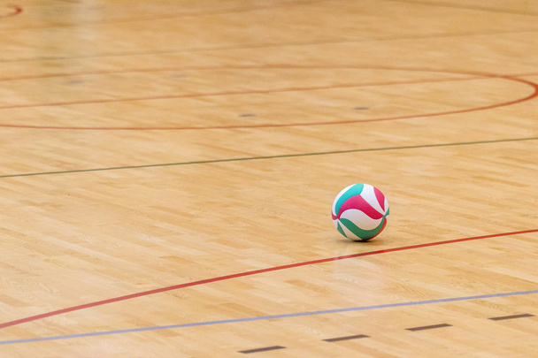 Volleyball ball on hardwood volleyball court - Photo, Image