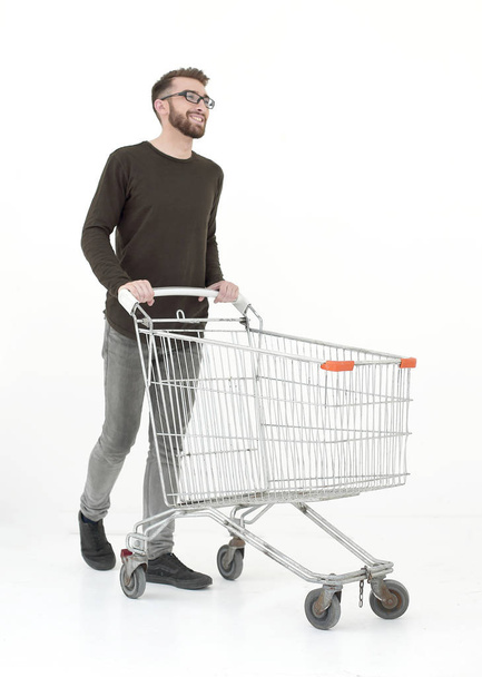 young man with a shopping cart steps forward - Zdjęcie, obraz