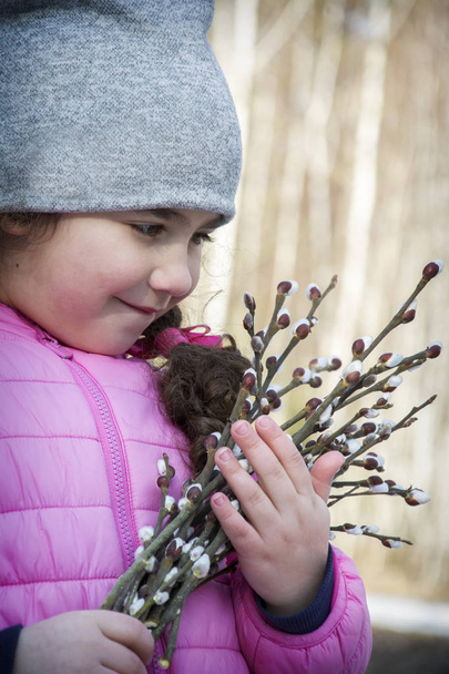 Na wiosnę w lesie stoi mała dziewczynka z bukietem  - Zdjęcie, obraz