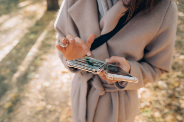 Красивая девушка держит в руках два смартфона
 - Фото, изображение