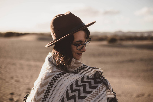 gözlük ve şapka ile rüzgarlı bir günde çölde genç kadın - Fotoğraf, Görsel