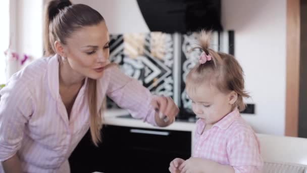 Mother cooking together with little daughter at kitchen - Felvétel, videó
