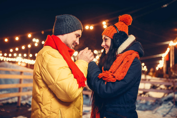 Soirée d'hiver, couple amoureux mains chaudes à l'extérieur. Homme et femme ayant une réunion romantique dans la rue de la ville avec des lumières
 - Photo, image