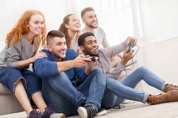 Разнообразные друзья играют в видеоигры, веселятся
 - Фото, изображение