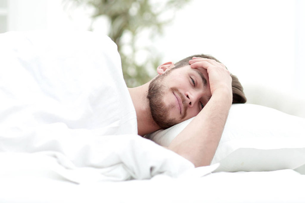 young man is sleeping in a comfortable hotel room - Zdjęcie, obraz