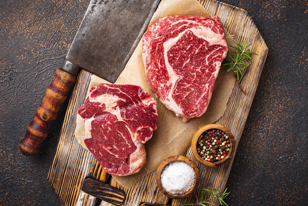 Raw marbled ribeye steak and butchers knife - Fotó, kép