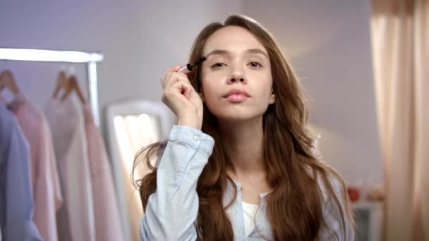 Young woman applying mascara. Beauty woman applying makeup at morning - Video, Çekim