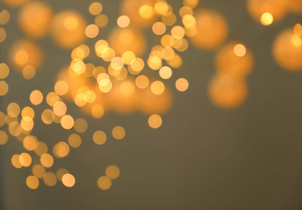 Blurred view of gold lights on dark background. Bokeh effect - Fotó, kép