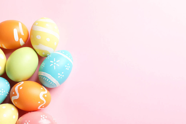 Many painted Easter eggs on color background, top view. Space for text - Foto, Bild