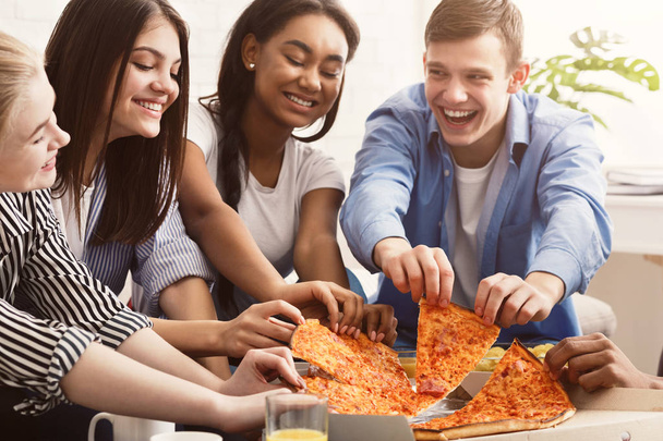 Friends eating pizza, spending time together at home - Foto, Imagen