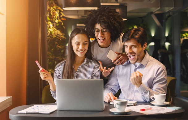 Успішна бізнес команда, дивлячись на ноутбук щасливо
 - Фото, зображення