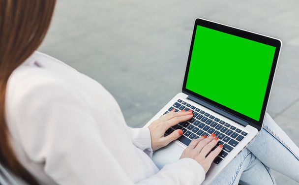 Mujer milenaria escribiendo en el ordenador portátil con pantalla verde
 - Foto, Imagen