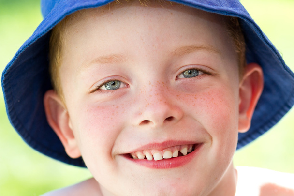 Netter kleiner Junge mit Sonnenhut im Garten, der vor Freude lächelt - Foto, Bild