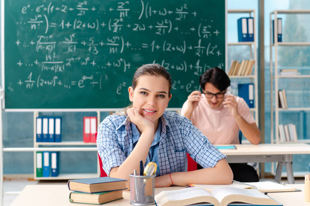 Jovens estudantes fazendo o exame de matemática em sala de aula
  - Foto, Imagem