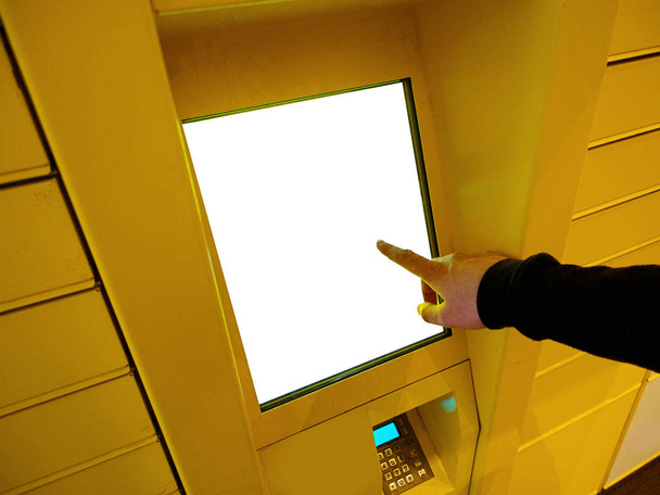 Close-up van Business man hand met behulp van elektronische Locker, geel geautomatiseerde perceel Terminal (Parcel Locker, post Terminal, E-Locker) op de straat met leeg scherm voor model, thuisbezorging. - Foto, afbeelding