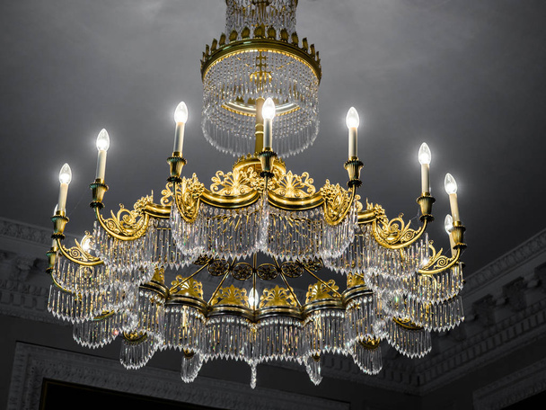 Antigua lámpara de araña vintage con velas en el techo de un palacio, sala de estar
. - Foto, imagen