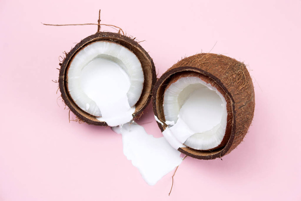 coconut with white liquid pain on a vibrant pink background - Foto, Bild