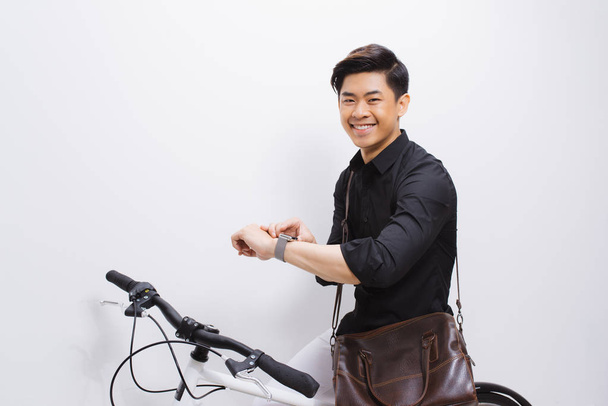 Handsome hipster enjoying a bike ride and checking time on his watch. - Photo, Image