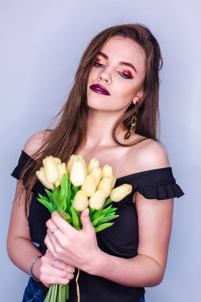 Beauty portrait of a woman with bright colorful make-up and bouquet of yellow tulips - Fotoğraf, Görsel