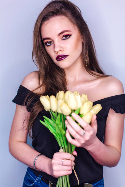 Beauty portrait of a woman with bright colorful make-up and bouquet of yellow tulips - Foto, Imagen
