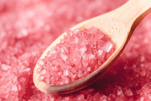Pink sea salt on a wooden measuring spoon, background - Photo, Image