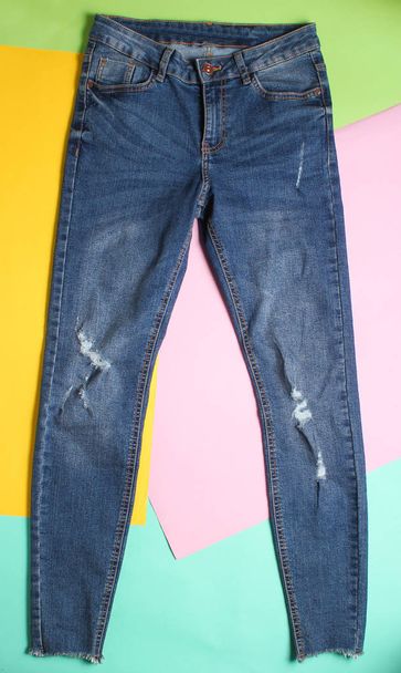 Female fashionable ragged faded jeans on a colored pastel background. Minimalism, top vie - Photo, Image