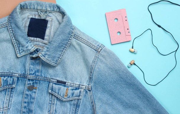 Kurtki jeansowe, kaseta magnetofonowa, próżniowe słuchawki na niebieskim tle pastel. Retro media, meloman, 80s. Widok z góry, płaskie la - Zdjęcie, obraz