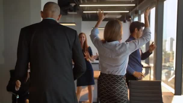 カメラの前でオフィスで元気に踊る魅力的な自信のあるビジネスマン - 映像、動画