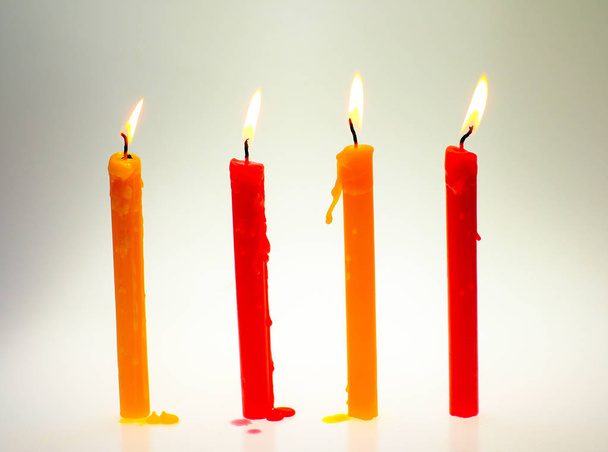 vier helle Flammenkerzen brennen hell auf weißem Hintergrund - Foto, Bild