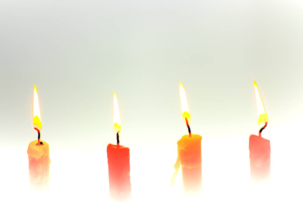 vier helle Flammenkerzen brennen hell auf weißem Hintergrund - Foto, Bild