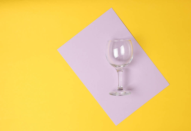 Άδειο ποτήρι κρασιού σε χρωματιστά παστέλ φόντο. Το top view. Minimalis - Φωτογραφία, εικόνα