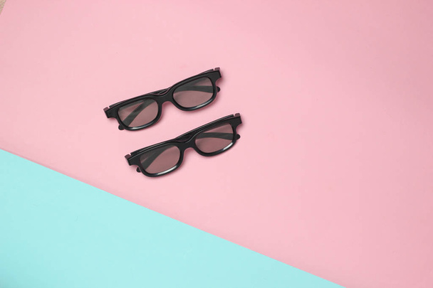 Дві пари 3d окулярів на рожево-блакитному пастельному тлі. Вид зверху. Мінімалізм
 - Фото, зображення