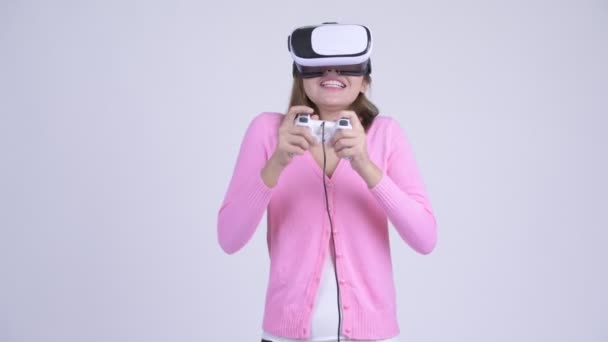 Young happy Asian woman playing games and using virtual reality headset - Imágenes, Vídeo